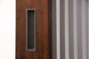 明治期の格子蔵戸をリペア&カスタム!設置場所に合わせてリサイズ。格子裏にスリガラスを入れ込み、戸車・サムターン錠、引き手を取り付け。現状の色に赤味を足した色味に着色し仕上げ。(引き戸、玄関戸、建具)