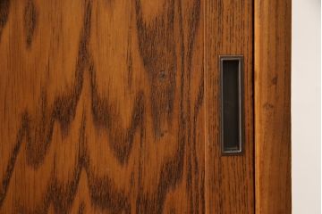 食器棚を綺麗に再生!高品質リペアを施し、棚板を作り替え。片開き戸の引手を取り替え、引き違い戸は取っ手を撤去し、引手を取り付け。濃茶色に塗装して仕上げ。