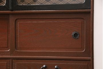 茶箪笥を使いやすくリメイク!ガラス戸がある段を、組子ガラス入りの観音扉仕様の棚に変更。扉に房付きの取っ手を取り付け。他の取っ手や引き手を交換し、脚を取り付け。既存の塗装は剥離し、深みのある赤色に着色仕上げ。