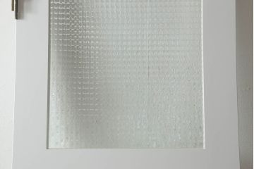 ドアを窓付ドアにリメイク!既存の小さな丸窓は穴埋めし、上部にチェッカーガラスをはめ込み明り取りを制作。