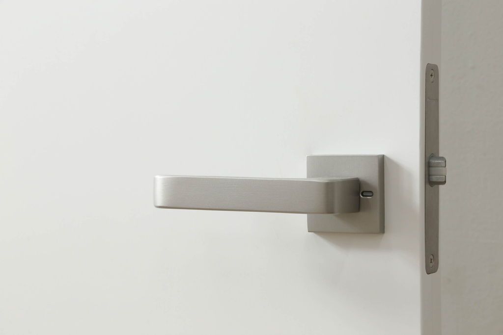 ドアを窓付ドアにリメイク!既存の小さな丸窓は穴埋めし、上部にチェッカーガラスをはめ込み明り取りを制作。