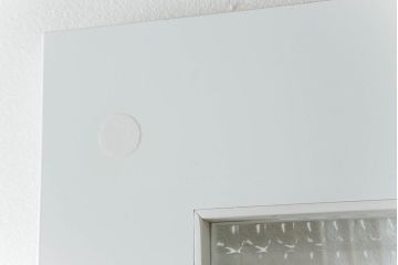 ドアを窓付ドアにリメイク!既存の小さな丸窓は穴埋めし、上部にチェッカーガラスをはめ込み明り取りを制作。