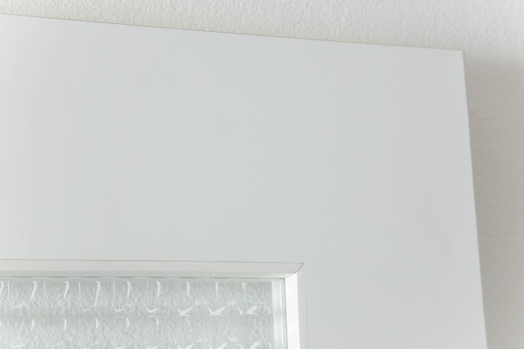 ドアを窓付ドアにリメイク!既存の小さな丸窓は穴埋めし、上部にチェッカーガラスをはめ込み明り取りを制作。