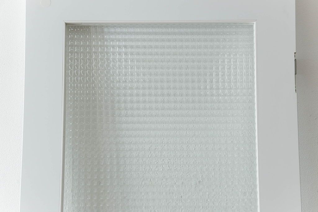 ドアを窓付ドアにリメイク!既存の小さな丸窓は穴埋めし、上部にチェッカーガラスをはめ込み明り取りを制作。