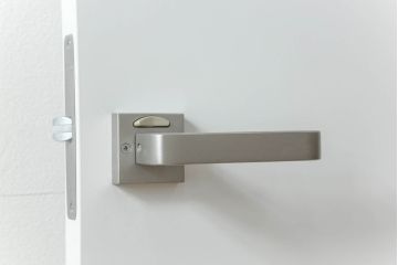 ドアを窓付ドアにリメイク!既存の小さな丸窓は穴埋めし、上部にチェッカーガラスをはめ込み明り取りを制作。