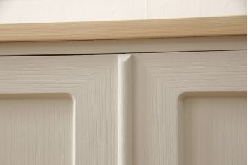 2段重ね桐箪笥をリビングボードとチェストにリメイク!上段は中央の仕切りと棚板を製作。取っ手を付け替え、本体をアンティークホワイトにペイント。下段は下2杯分をカットし、自然な木地色仕上げに。いずれも天板と脚を取り付け。