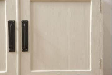 2段重ね桐箪笥をリビングボードとチェストにリメイク!上段は中央の仕切りと棚板を製作。取っ手を付け替え、本体をアンティークホワイトにペイント。下段は下2杯分をカットし、自然な木地色仕上げに。いずれも天板と脚を取り付け。