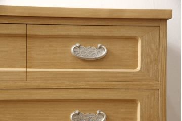 2段重ね桐箪笥をリビングボードとチェストにリメイク!上段は中央の仕切りと棚板を製作。取っ手を付け替え、本体をアンティークホワイトにペイント。下段は下2杯分をカットし、自然な木地色仕上げに。いずれも天板と脚を取り付け。