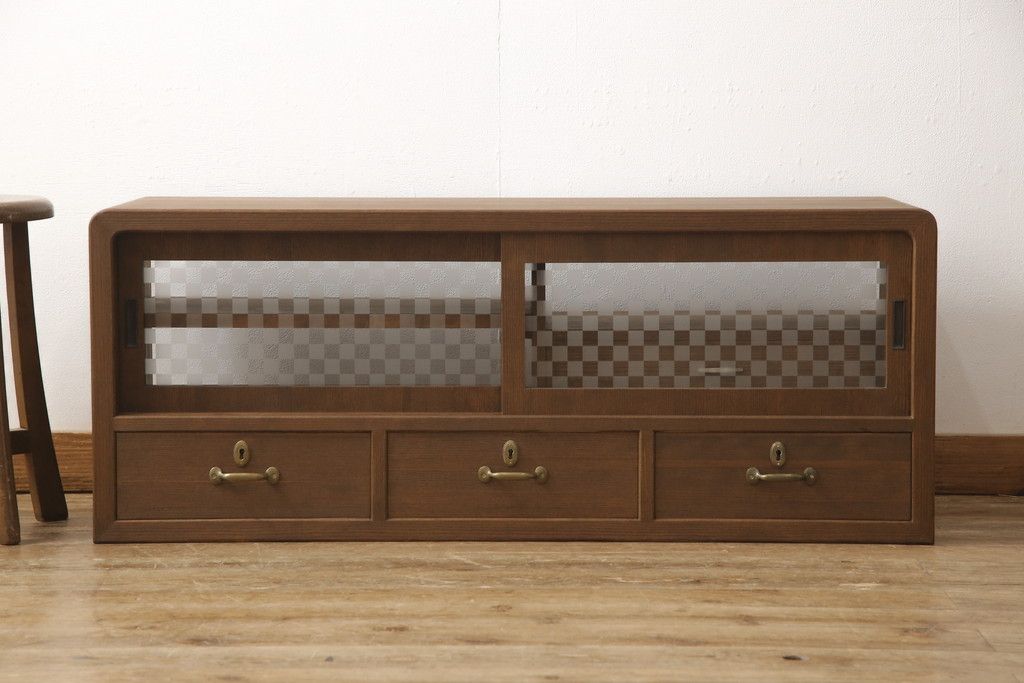 桐箪笥の上段を用いてローボードにリメイク!高さと奥行きをリサイズ。棚を製作し、背面はオープンに。引き戸は市松模様のガラスをはめ込み、取っ手と鍵金具を交換。チェスナット系に着色仕上げ。