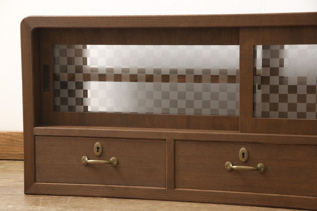 桐箪笥の上段を用いてローボードにリメイク!高さと奥行きをリサイズ。棚を製作し、背面はオープンに。引き戸は市松模様のガラスをはめ込み、取っ手と鍵金具を交換。チェスナット系に着色仕上げ。