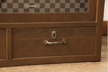 桐箪笥の上段を用いてローボードにリメイク!高さと奥行きをリサイズ。棚を製作し、背面はオープンに。引き戸は市松模様のガラスをはめ込み、取っ手と鍵金具を交換。チェスナット系に着色仕上げ。