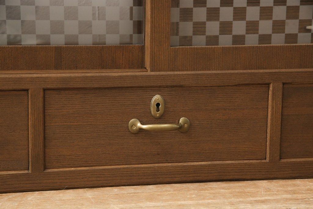 桐箪笥の上段を用いてローボードにリメイク!高さと奥行きをリサイズ。棚を製作し、背面はオープンに。引き戸は市松模様のガラスをはめ込み、取っ手と鍵金具を交換。チェスナット系に着色仕上げ。