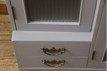 書棚を使いやすくリメイク!上部のオープン部分をカットし、天板を設置。ガラスが欠損した部分にモールガラスをはめ込み、背板を新材に交換。両開き戸内の底面を補強して、台輪をカットし脚を取り付け。取っ手・引手を交換して、ご希望の色に着色仕上げ。