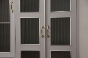 書棚を使いやすくリメイク!上部のオープン部分をカットし、天板を設置。ガラスが欠損した部分にモールガラスをはめ込み、背板を新材に交換。両開き戸内の底面を補強して、台輪をカットし脚を取り付け。取っ手・引手を交換して、ご希望の色に着色仕上げ。