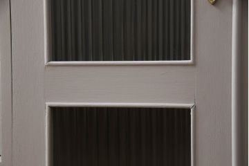 書棚を使いやすくリメイク!上部のオープン部分をカットし、天板を設置。ガラスが欠損した部分にモールガラスをはめ込み、背板を新材に交換。両開き戸内の底面を補強して、台輪をカットし脚を取り付け。取っ手・引手を交換して、ご希望の色に着色仕上げ。