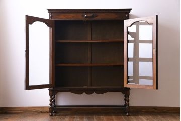 アンティーク家具　イギリスアンティーク　シンプルな扉のデザインとツイストレッグが魅力的なブックケース(本箱、本棚、キャビネット)